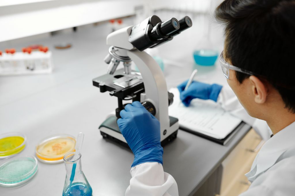Scientist examining samples through a laboratory microscope